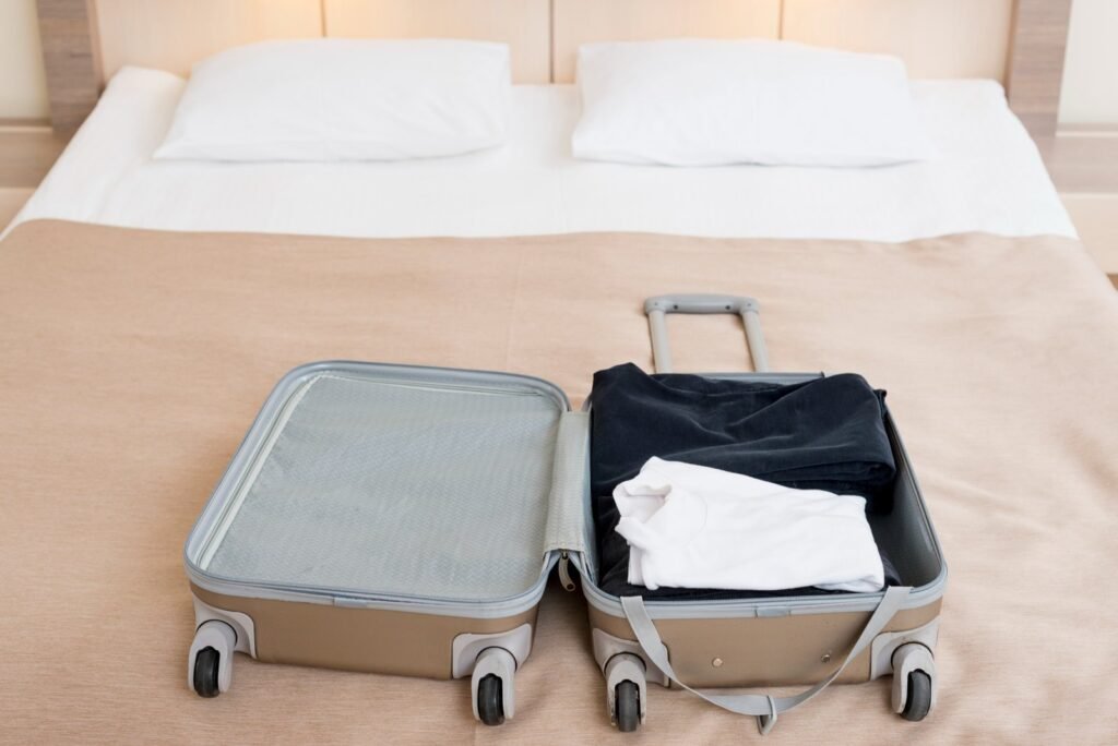 Chambre prête à accueillir un voyageur, valise posée sur le lit